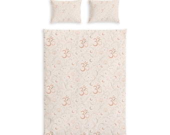May include: A bedding set consisting of a rectangular duvet cover and two matching rectangular pillowcases. The fabric features a light beige background with a repeating pattern of orange Om symbols, thin swirling vines, small flowers, and crescent moons.