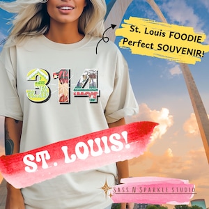 May include: A beige t-shirt with a graphic design of the number 314 made up of images of St. Louis food. The text "St. Louis FOODIE Perfect SOUVENIR!" is in the top right corner of the image. The text "ST. LOUIS!" is in the bottom left corner of the image. The text "SASS N SPARKLE STUDIO" is in the bottom right corner of the image.