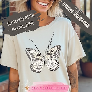 May include: A light beige t-shirt with a black and white butterfly graphic and the text "Butterfly Birth Month, JUNE" and "June" written in cursive. The text "SASS N SPARKLE STUDIO" is at the bottom of the shirt.