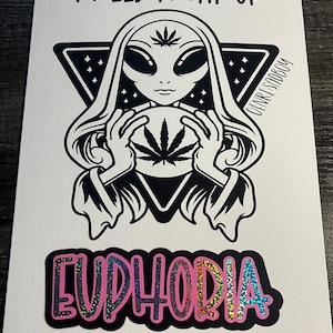 May include: A black and white illustration of an alien holding a marijuana leaf in a circle. The text "I need a hit of" is above the alien and the text "Euphoria" is below the alien in pink with a glittery effect.