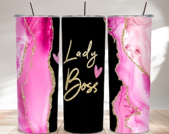 Könnte beinhalten: Drei Edelstahlbecher mit Deckeln und Strohhalmen. Zwei haben ein rosa-goldenes Achat-Design, der mittlere ist schwarz mit "Lady Boss" in goldener Schrift und rosa Herzen. Ideal für kalte Getränke.