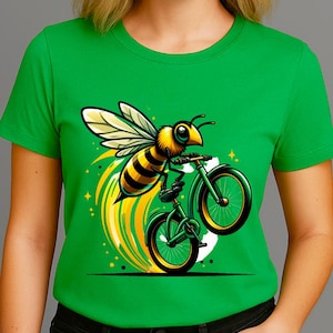 May include: Green t-shirt featuring a cartoon bee riding a green bicycle. The bee is yellow and black with white wings, and the bicycle has yellow accents. The design includes yellow and green streaks and starbursts.