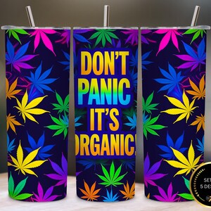 May include: A set of three stainless steel tumblers with a dark blue background and colorful cannabis leaves. The center tumbler has the text "DON'T PANIC IT'S ORGANIC" in rainbow colors. Each tumbler has a silver straw.