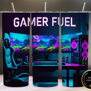 May include: Three stainless steel tumblers with the words "GAMER FUEL" in white. Each tumbler features a gaming setup design with a computer, monitor, and gaming chair. The design includes neon blue, purple, and pink colors.