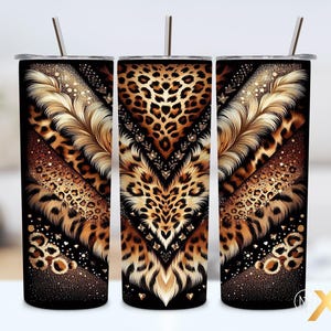May include: Three stainless steel tumblers with a decorative design. The design features a leopard print pattern, gold feathers, and sparkling accents. Each tumbler has a silver straw and a black lid.