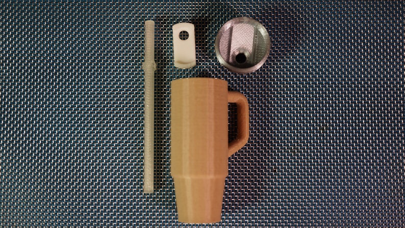May include: A brown travel mug with a lid and a handle. The mug is made of stainless steel and has a double-walled construction to keep drinks hot or cold. The mug comes with a straw and a lid with a built-in straw hole.