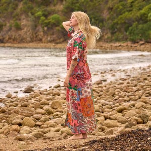 Puede incluir: Un vestido largo hasta el suelo con un dise&ntilde;o de patchwork vibrante que presenta varios patrones florales y de cachemira en tonos rosa, naranja, verde y azul. La prenda tiene mangas cortas, cuello camisero y cierre frontal de botones.
