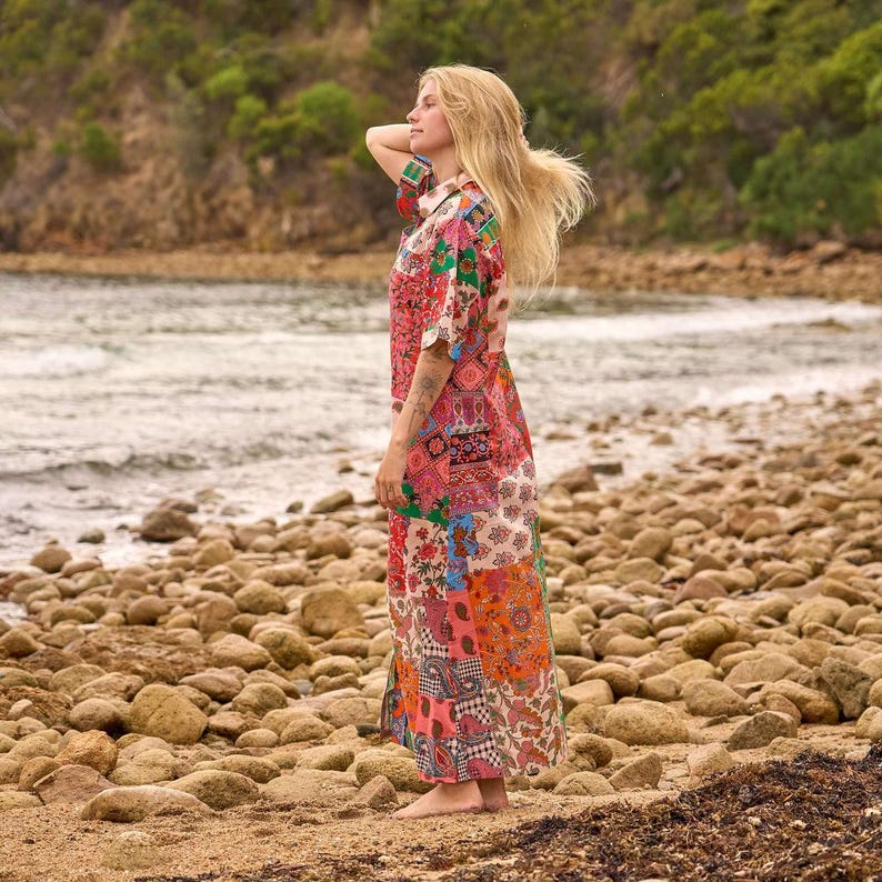 Puede incluir: Un vestido largo hasta el suelo con un dise&ntilde;o de patchwork vibrante que presenta varios patrones florales y de cachemira en tonos rosa, naranja, verde y azul. La prenda tiene mangas cortas, cuello camisero y cierre frontal de botones.