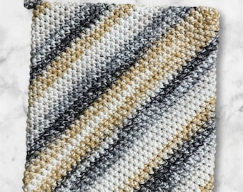 May include: A square crochet potholder featuring a diagonal striped pattern in shades of tan, white, charcoal gray, and black. The textile has a thick, textured stitch construction and includes a small loop at the top corner for hanging.