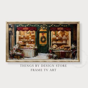 Puede incluir: Una impresión artística digital enmarcada que representa una escena de panadería en invierno. La panadería tiene un toldo rojo y está decorada con luces navideñas y una corona. El escaparate muestra varios productos horneados. El marco es dorado y la obra de arte está etiquetada como "THINGS BY DESIGN STORE FRAME TV ART."