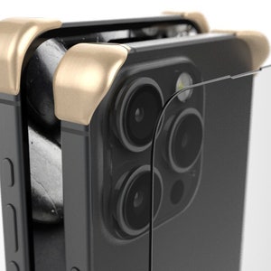 May include: A black smartphone with a gold-colored case. The phone has a triple camera system on the back.