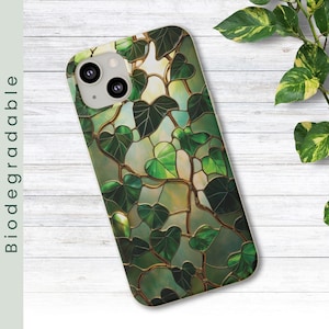 May include: A green and gold phone case with a stained glass design of leaves.