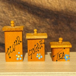 Vintage 1:12 scale dollhouse set of three wooden canisters (flour, sugar, tea).