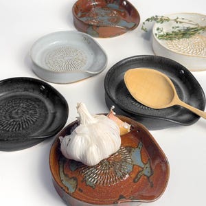 5-in-1 Ceramic garlic/ginger grater, spoon rest, herb stripper, and olive oil dipper
