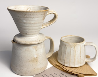 Juego de cerámica para preparar café vertido a medida: jarra, taza y filtros.