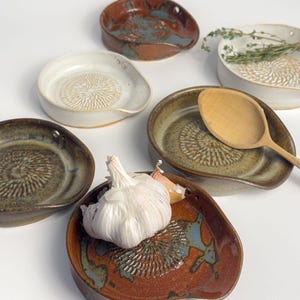 5-in-1 Ceramic garlic/ginger grater, spoon rest, herb stripper, and olive oil dipper