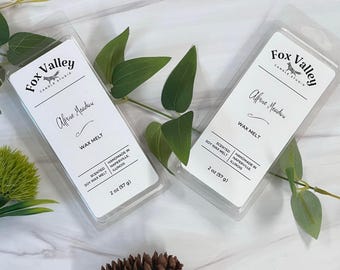 May include: Two clear plastic clamshell packages containing wax melts, each with a white label reading Fox Valley Candle Studio, Alpine Meadow, and 2 oz (57 g). The labels also state Scented Soy Wax Melt and Handmade in Naperville, Illinois.