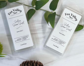 May include: Two rectangular clear plastic clamshell packages containing wax melts. The white labels feature the text Fox Valley Candle Studio, Southern Summer Sunset, Scented Soy Wax Melt, Handmade in Naperville, Illinois, and 2 oz (57 g).