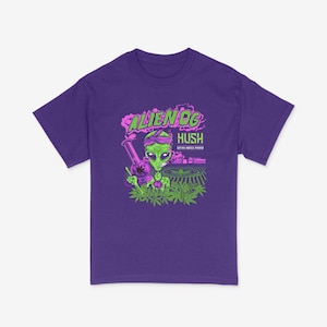 May include: Purple t-shirt featuring a green alien holding a bong and wearing a bandana. The text "ALIEN OG" and "HUSH SATIVA INDICA HYBRID" is printed on the shirt.