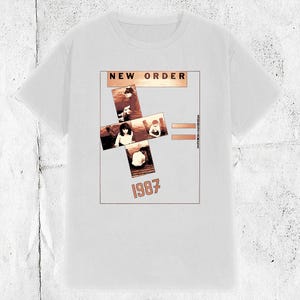 May include: A white t-shirt with a graphic print of a cross made up of four photos of the band New Order. The text "NEW ORDER" is at the top of the graphic and "1987" is at the bottom. The text "SUBSTANCE" is to the right of the cross.