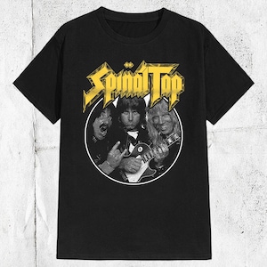 May include: Black t-shirt with a yellow graphic of the band Spinal Tap. The graphic features three band members with guitars.