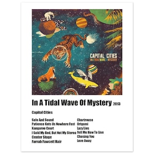 May include: Album cover art for the album "In A Tidal Wave Of Mystery" by Capital Cities. The album cover features a colourful, psychedelic illustration of a tiger wearing a helmet, a walrus, a whale, and planets against a dark blue starry background. The album title and artist name are printed in white text on a black rectangle.