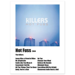 Op de afbeelding: Albumhoes voor "Hot Fuss" van The Killers. De albumhoes toont een stadsbeeld met een blauwe lucht en rode lichten. De albumtitel "Hot Fuss" en de bandnaam "The Killers" zijn in witte tekst op een zwarte achtergrond gedrukt.