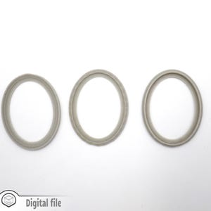 Peut inclure: Trois anneaux gris ovales, chacun avec un bord légèrement surélevé, sont disposés en rangée sur une surface blanche.