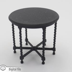Puede incluir: Una pequeña mesa redonda negra con una superficie texturizada y patas retorcidas ornamentadas. La mesa tiene una base en forma de cruz y pies decorativos. El texto "Digital file" está en la esquina inferior izquierda.