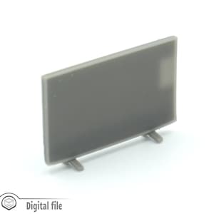 Op de afbeelding: Een grijs plastic model van een televisie met een plat scherm en twee kleine pootjes. Het model is ontworpen om te worden gebruikt in miniatuursettings.