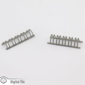 Puede incluir: Dos secciones de valla de plástico gris, una curva y una recta, para modelismo ferroviario o escenas en miniatura.