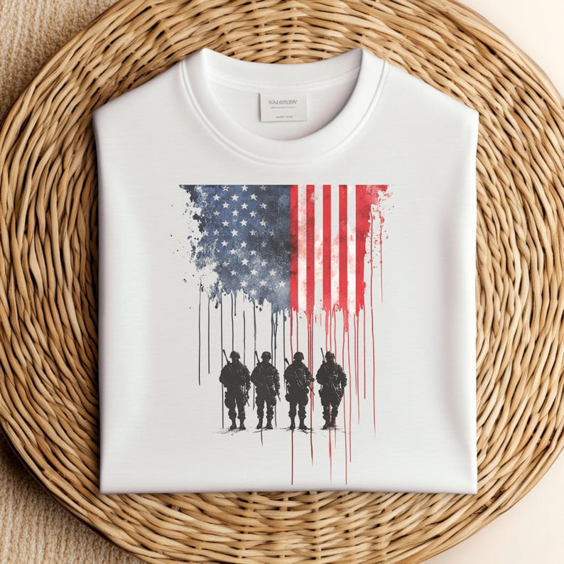 May include: White sweatshirt featuring an American flag design with a distressed effect. The flag transitions into a silhouette of four soldiers. The word "SALESON" is printed on the label. The sweatshirt is displayed on a woven surface.