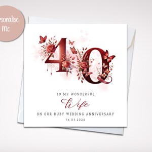 May include: A white card with a red 40 surrounded by red roses and butterflies. The text reads "To my wonderful wife on our ruby wedding anniversary 16.03.2024".