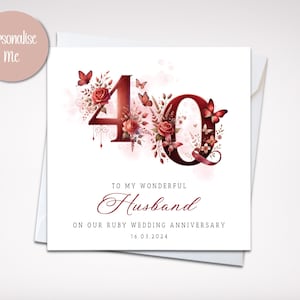 May include: A white card with a red 40 surrounded by red roses and butterflies. The text reads "To my wonderful Husband on our Ruby Wedding Anniversary 16.03.2024".