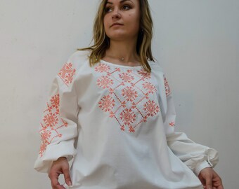 Oversized white blouse with orange embroidery made of natural fabrics, long sleeve