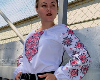 White cotton or linen blouse with cross-stitched pattern, long sleeves