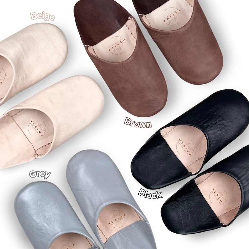 Puede incluir: Seis pares de zapatillas de cuero en beige, marr&oacute;n, gris y negro. Las zapatillas son todas del mismo estilo, con punta redonda y suela plana. El nombre de la marca "HERIMA" es visible en el interior de cada zapatilla.