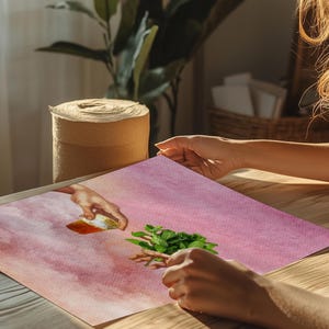 May include: A pink watercolour painting of two hands reaching towards each other. One hand is holding a small jar of honey, and the other hand is holding a sprig of fresh mint.