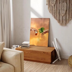 May include: A digital art print of a painting depicting two hands reaching towards each other. One hand is holding a small cup of liquid, while the other hand is holding a sprig of green leaves. The background is a soft orange and yellow gradient.