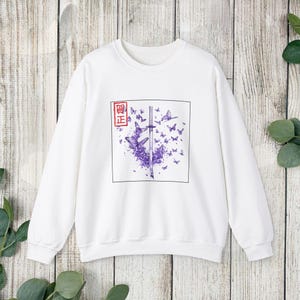 May include: White sweatshirt with a purple butterfly and sword graphic. The graphic includes the text "偖正" in a red square.