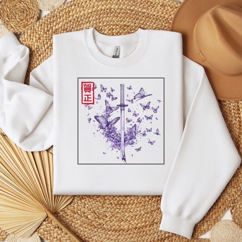 May include: White sweatshirt with a purple and black graphic design of a katana sword with butterflies and the Japanese word "Seigi" in red.