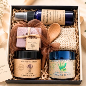 May include: A gift box containing a 2.5oz bottle of Throne & Key Lavender Magnesium Spray, a Clay Salt Bar, a wooden spoon, a textured washcloth, a jar of Lavender Magnesium Cream, and a jar of Organic Aloe-Cucumber Sugar Scrub.