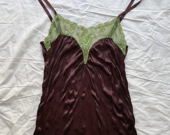 Puede incluir: Una camisola de color marrón oscuro con escote en V y una superposición de malla transparente de color verde claro. El panel de malla está decorado con bordados intrincados y lentejuelas verdes a juego. Tiene tirantes finos y acabado satinado.