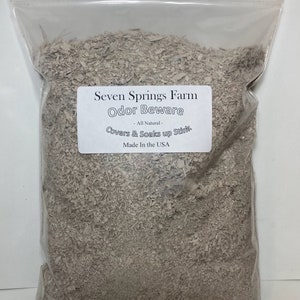 May include: A white plastic bag filled with a light brown, shredded material. The bag has a white label that reads "Seven Springs Farm Odor Beware - All Natural - Covers & Soaks up Stink Made In the USA".