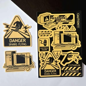 May include: A collection of yellow and black stickers featuring computer-themed warning signs. Designs include a danger sparks flying triangle, a computer setup, and various caution labels with text like WARNING OVERHEATING and ELECTRICAL HAZARD.