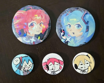 Peut inclure: Deux grands badges ronds holographiques représentant des personnages de style anime aux cheveux roses et bleus, accompagnés de trois petits badges ronds avec des illustrations au trait noir et blanc de personnages portant des casques.