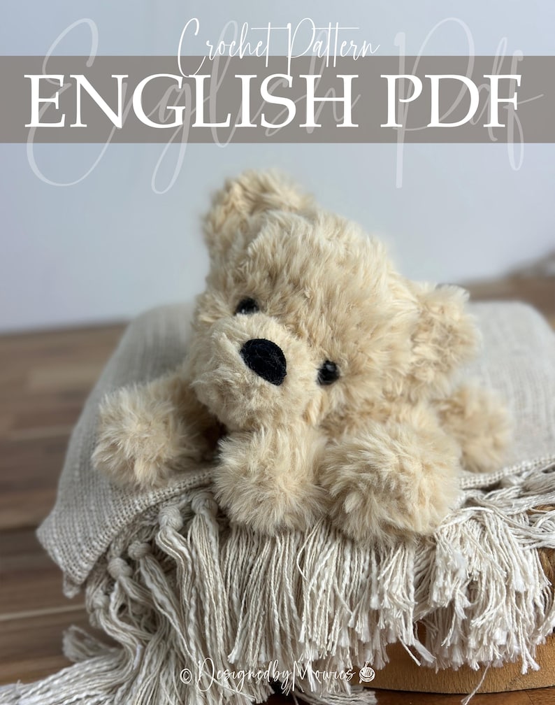 May include: A plush, beige teddy bear with a black nose and eyes rests on a fringed blanket. The image includes the text "Crochet Pattern ENGLISH PDF" in a decorative font, suggesting a downloadable crochet pattern.