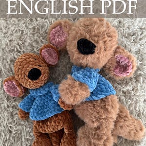 Op de afbeelding: Twee gehaakte teddyberen in bruintinten, met blauwe truien. De beren hebben roze binnenoren en zwarte neuzen. De afbeelding bevat de tekst "Crochet Pattern ENGLISH PDF" en de naam van de ontwerper.