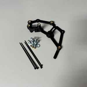 May include: Black plastic bracket with six gold screws, four silver screws, and three black zip ties.