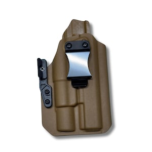 May include: Tan-colored polymer holster with a black belt clip and adjustable cant. The holster features a molded design for secure firearm retention. The clip is made of shiny metal. The holster is designed for concealed carry.